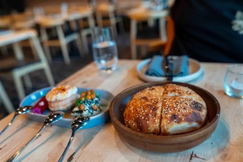 Warm Turkish bread and entrées on a pine table in the Rakkas dining room, from the AGFG article